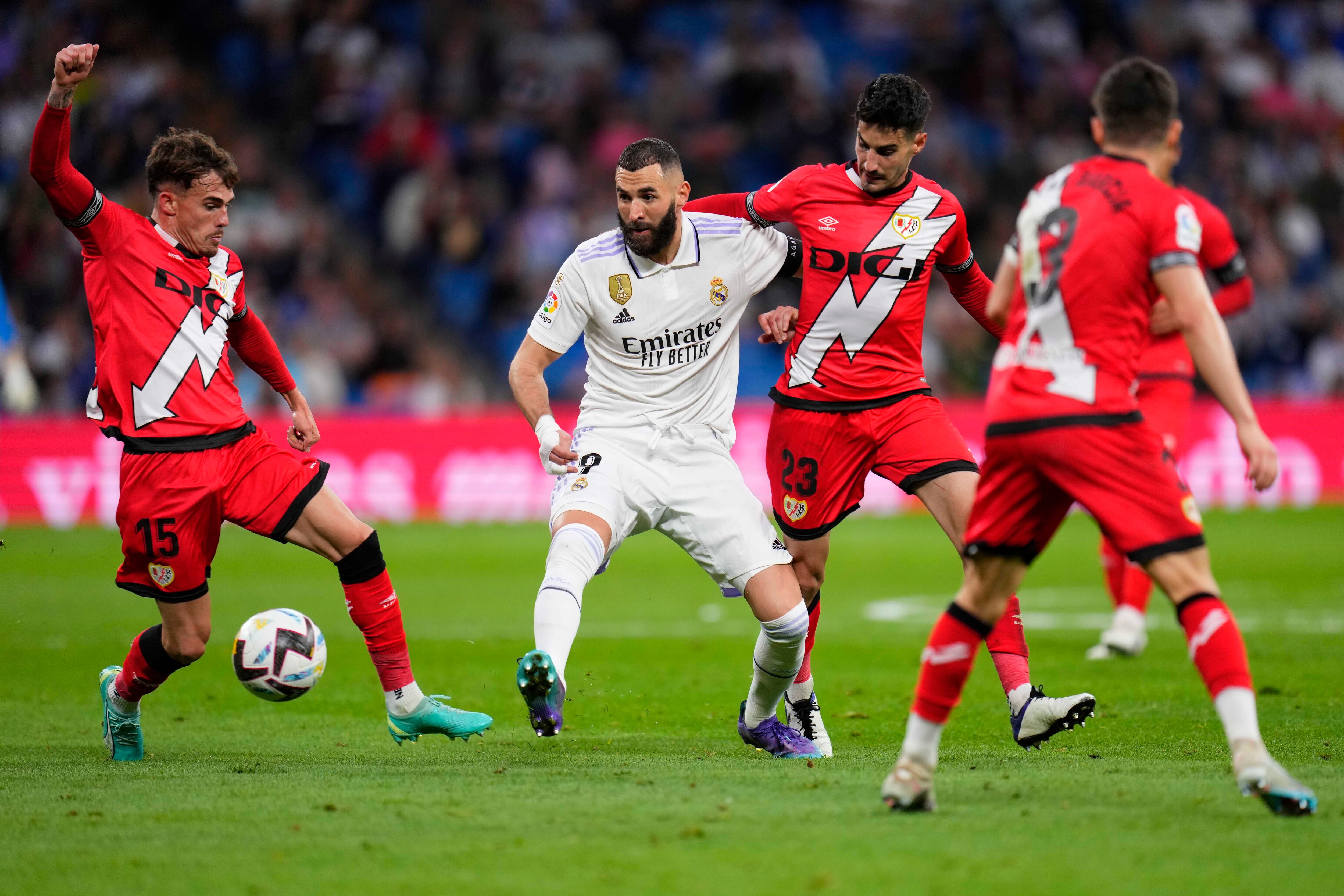Rayo's Pep Chavarria, from left, Real Madrid's Karim Benzema, and Rayo's Oscar Valentin challenge for the ball during a Spanish La Liga soccer match between Real Madrid and Rayo Vallecano at the Santiago Bernabeu stadium in Madrid, Spain, Wednesday, May 24, 2023. (AP Photo/Manu Fernandez)