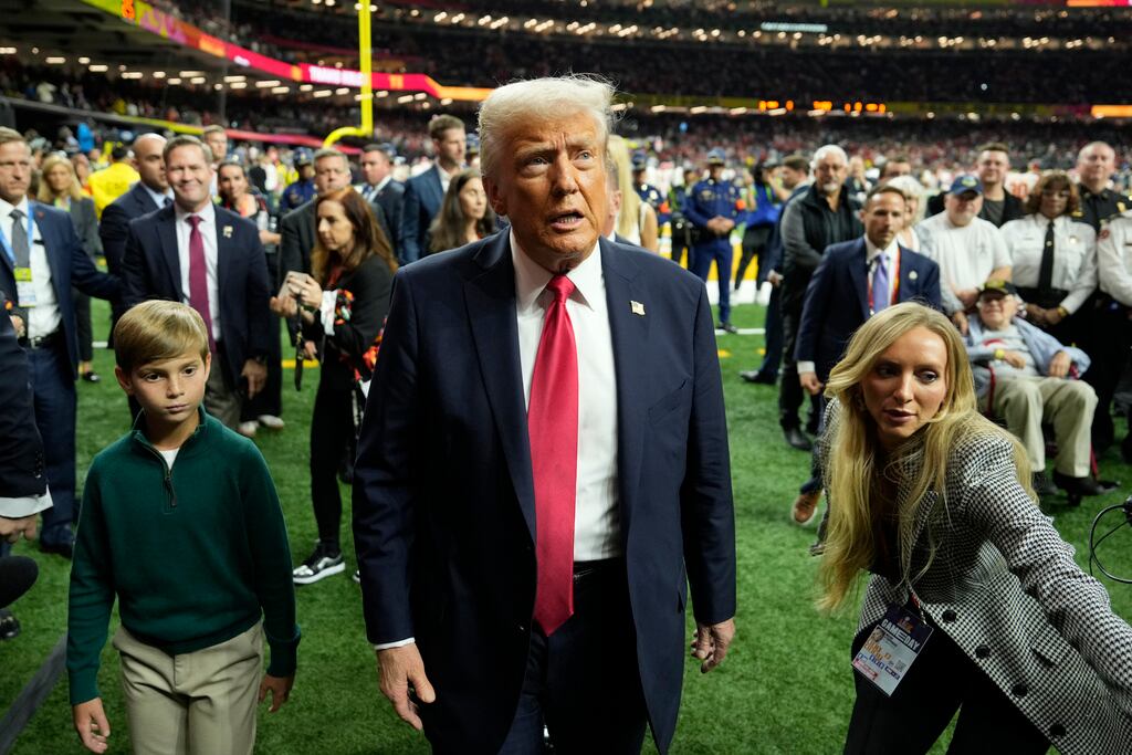 El presidente Donald Trump, en el centro, con su nieto Theodore, camina por el campo antes del inicio del partido de fútbol americano Super Bowl 59 de la NFL entre los Philadelphia Eagles y los Kansas City Chiefs, el domingo 9 de febrero de 2025, en Nueva Orleans.