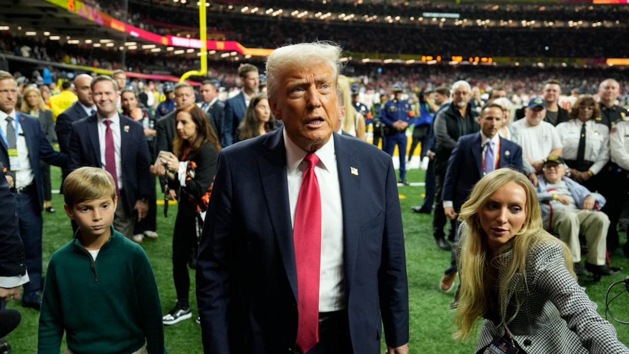 El presidente Donald Trump, en el centro, con su nieto Theodore, camina por el campo antes del inicio del partido de fútbol americano Super Bowl 59 de la NFL entre los Philadelphia Eagles y los Kansas City Chiefs, el domingo 9 de febrero de 2025, en Nueva Orleans.