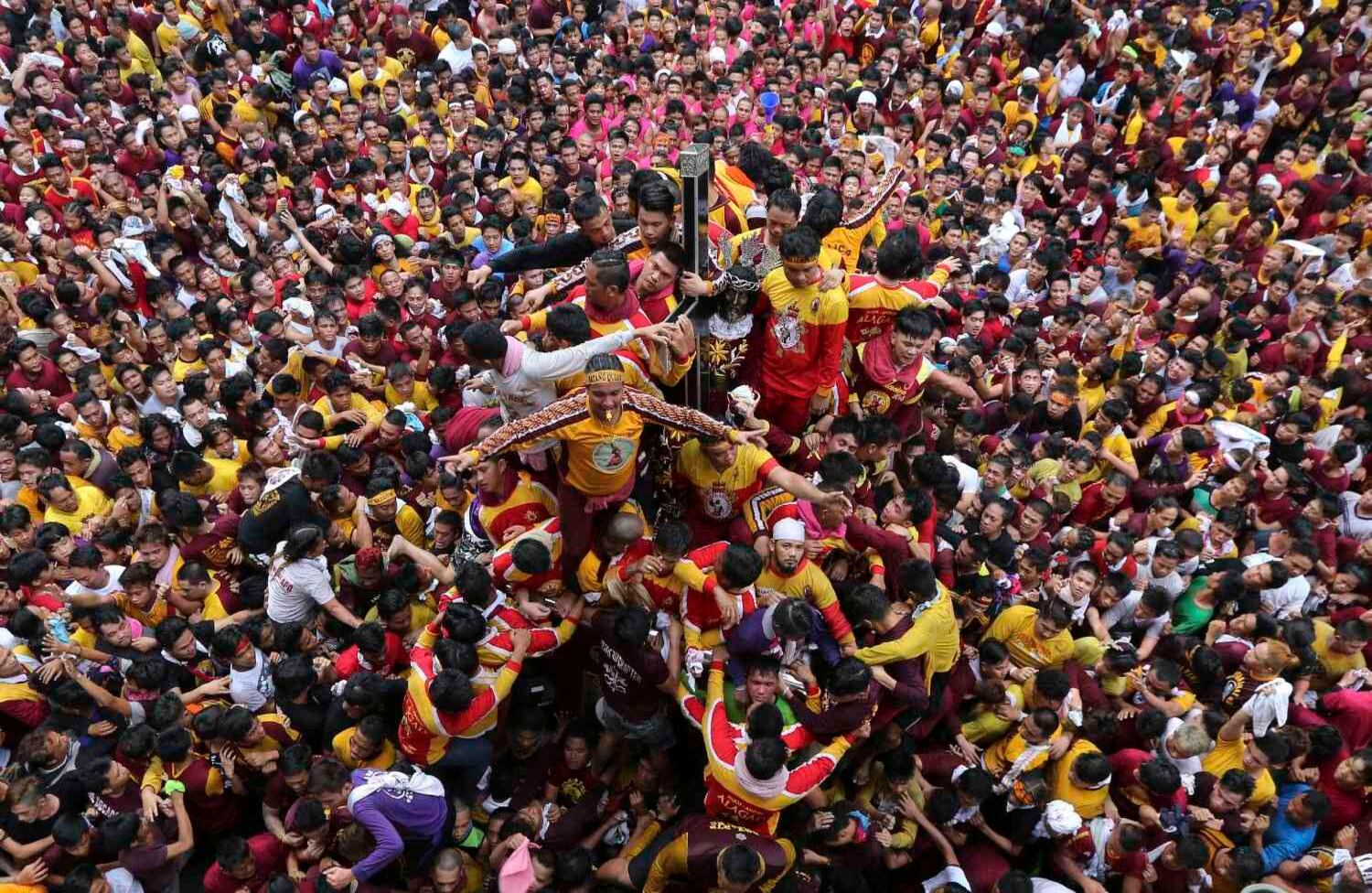 Los devotos católicos filipinos se disputan la posición mientras intentan acercarse a la imagen del Nazareno Negro durante una estridente procesión para celebrar su fiesta en Manila, Filipinas. (AP Photo / Aaron Favila, archivo).