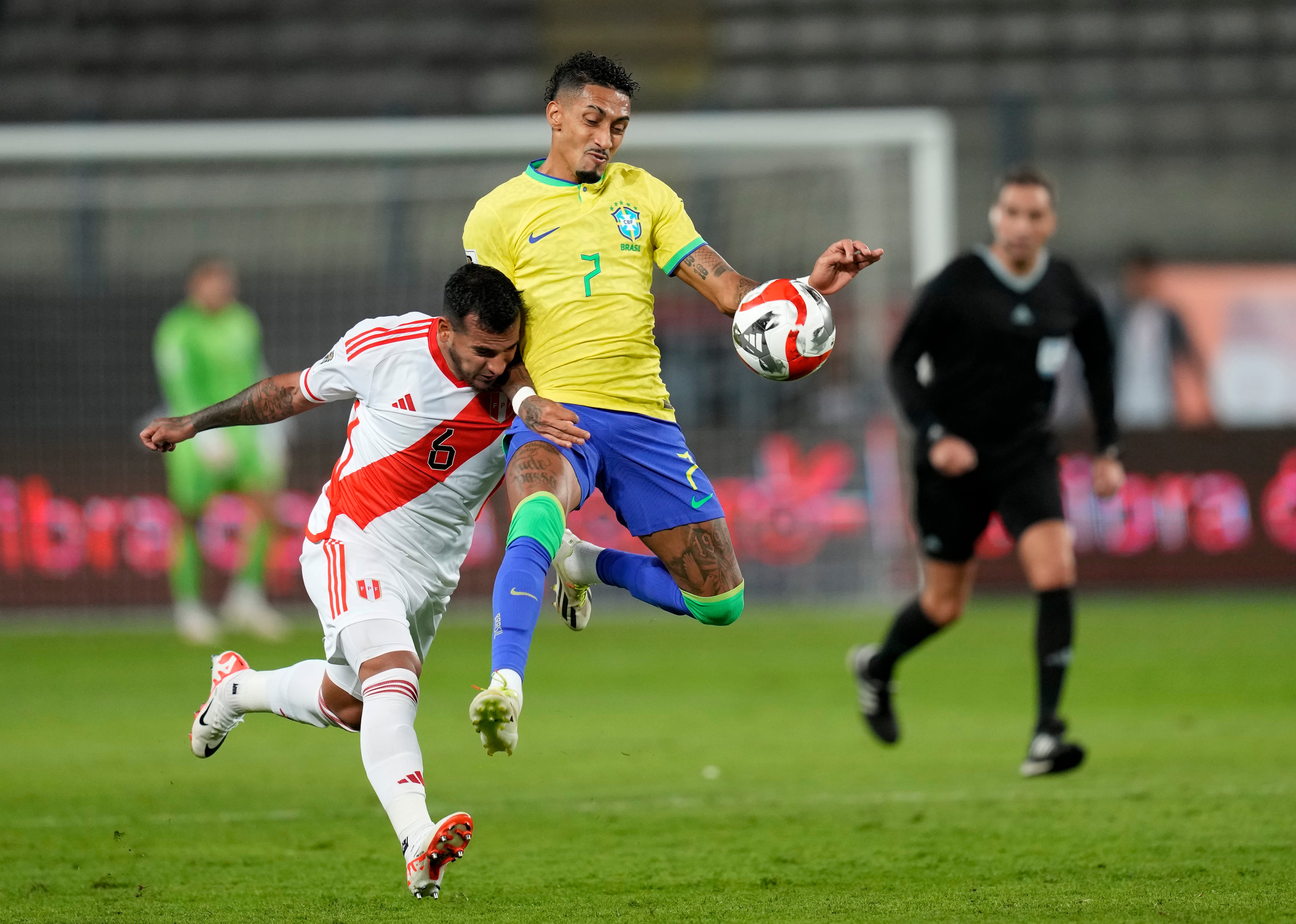 Raphinha disputa un balón ante el eruano Miguel Trauco,  en el partido de las eliminatorias Sudamericanas 2026.