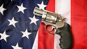 Una pistola apoyada sobre una bandera estadounidense, que representa la Segunda Enmienda de la Constitución de los Estados Unidos, el derecho de los estadounidenses patrióticos a portar armas.