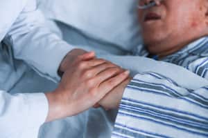 Enfermera cuida a una persona enferma. Imagen de referencia