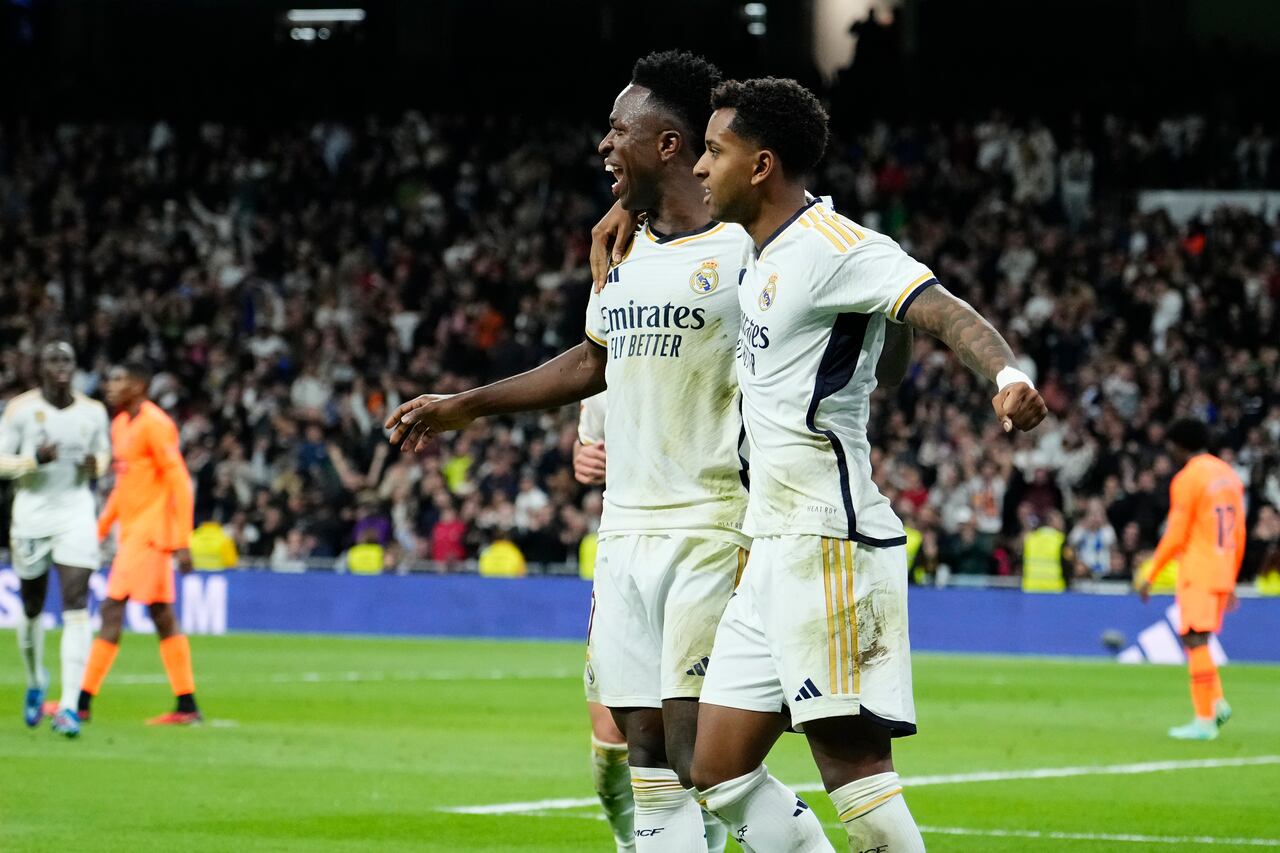 Real Madrid's Vinicius Junior, centre, celebrates with Rodrygo after scoring his side's third goal during the Spanish La Liga soccer match between Real Madrid and Valencia at the Santiago Bernabeu stadium in Madrid, Spain, Saturday, Nov. 11, 2023. (AP Photo/Jose Breton)