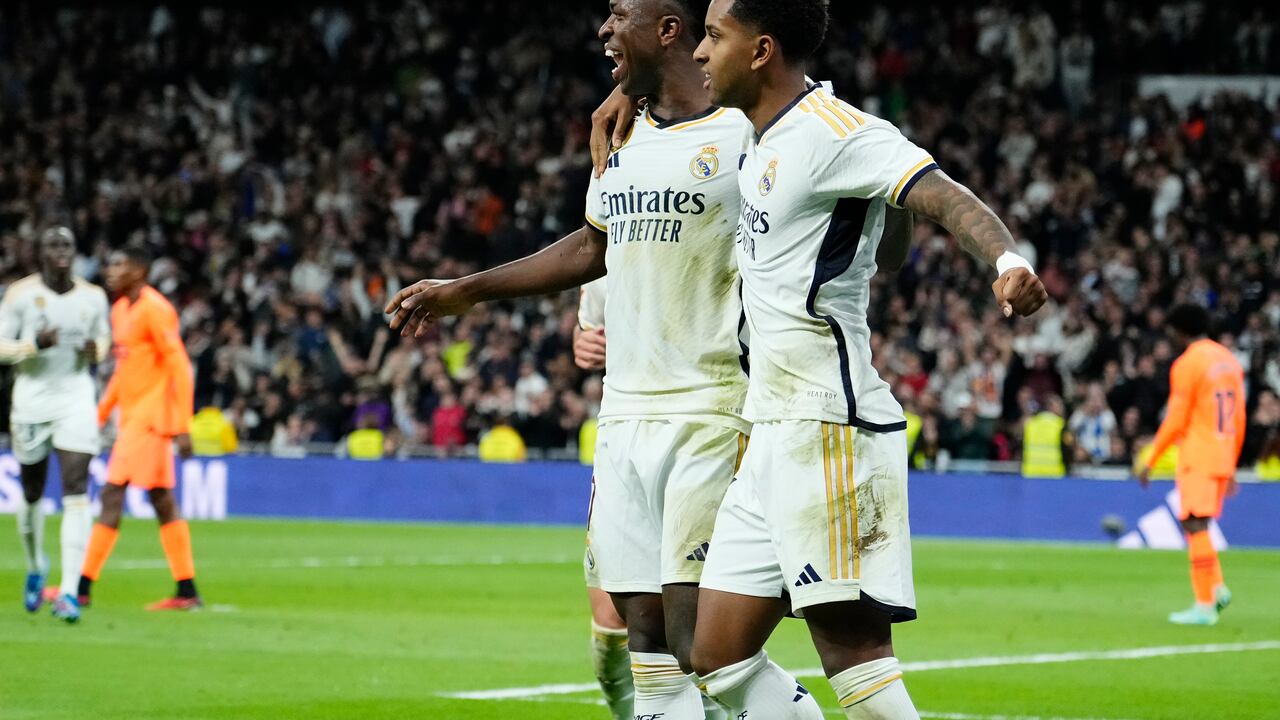 Real Madrid's Vinicius Junior, centre, celebrates with Rodrygo after scoring his side's third goal during the Spanish La Liga soccer match between Real Madrid and Valencia at the Santiago Bernabeu stadium in Madrid, Spain, Saturday, Nov. 11, 2023. (AP Photo/Jose Breton)