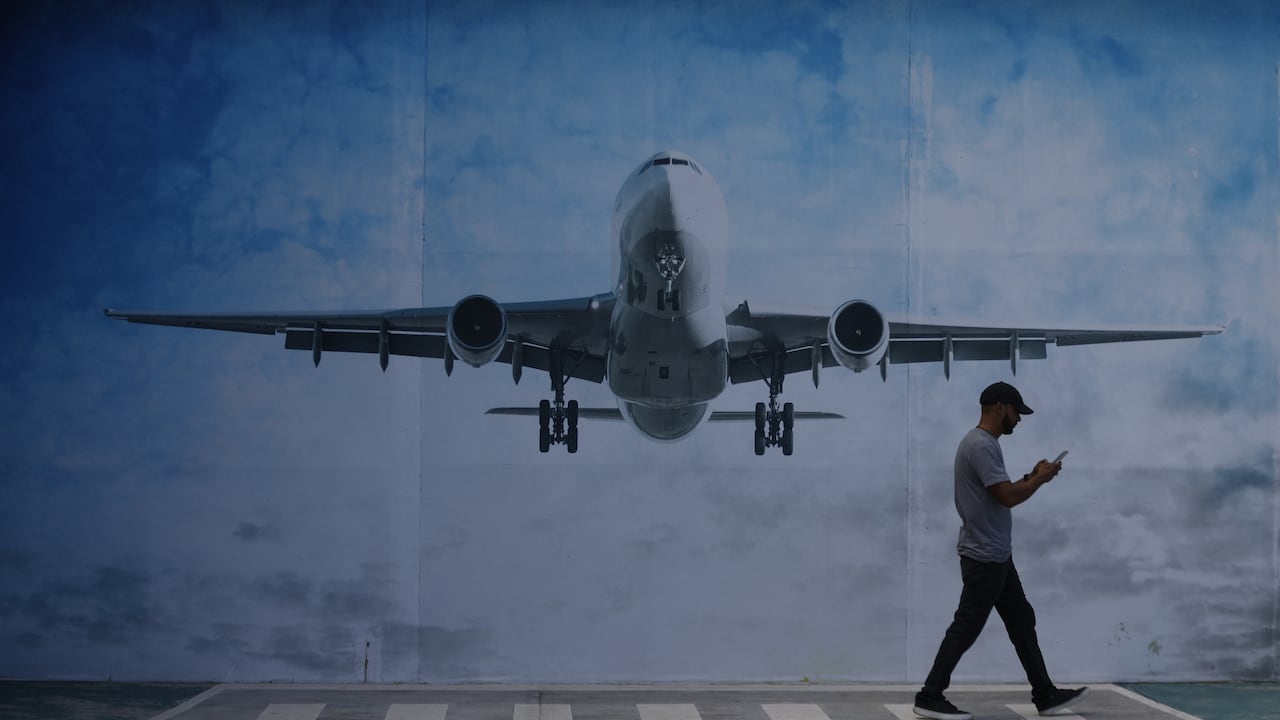 LA GUAIRA, VENEZUELA - NOVEMBER 30: A man walks next to a mural of an airplane in La Guaira State, Venezuela, on November 30, 2025. US President Donald Trump significantly escalated his threats against Venezuela on Saturday with an ominous warning that the country's airspace should be considered “closed,�? raising fears of imminent military action. Pedro Mattey / Anadolu (Photo by Pedro Mattey / Anadolu via AFP)