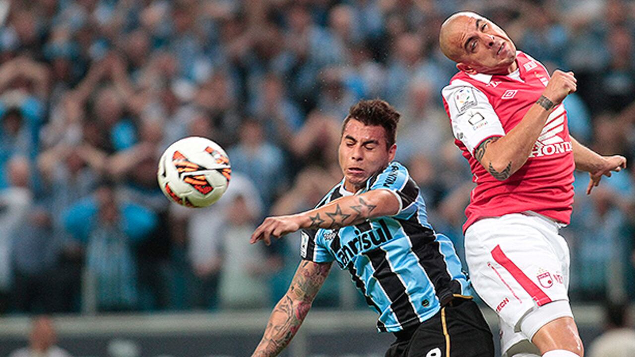 El jugador Vargas de Gremio de Brasil disputa el balón con Omar Pérez.