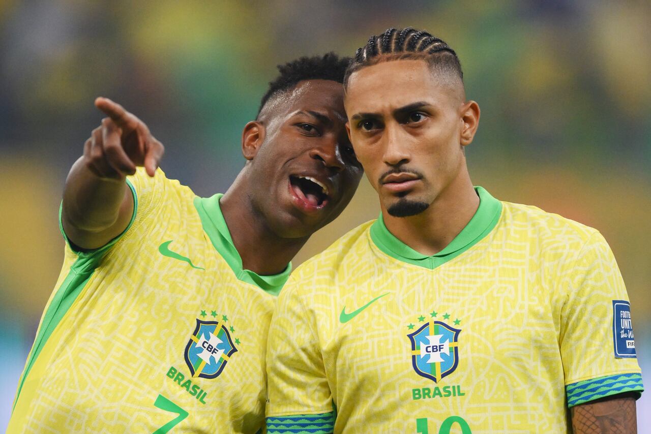 SALVADOR, BRAZIL - NOVEMBER 19: Vinicius Junior and Raphinha of Brazil talk as they line up prior to the South American FIFA World Cup 2026 Qualifier match between Brazil and Uruguay at Arena Fonte Nova on November 19, 2024 in Salvador, Brazil. (Photo by Pedro Vilela/Getty Images)