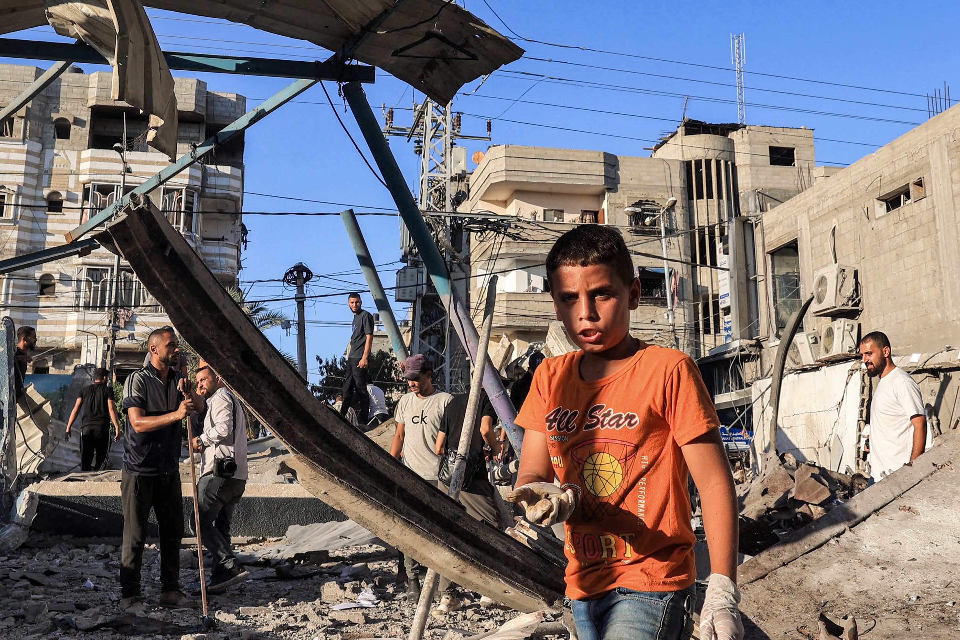 A boy inspects the rubble of a collapsed building in the aftermath of Israeli bombardment at the Jaouni school run by the UN Relief and Works Agency for Palestine Refugees (UNRWA) in Nuseirat in the central Gaza Strip on July 6, 2024 amid the ongoing conflict in the Palestinian territory between Israel and Hamas. (Photo by Eyad BABA / AFP)