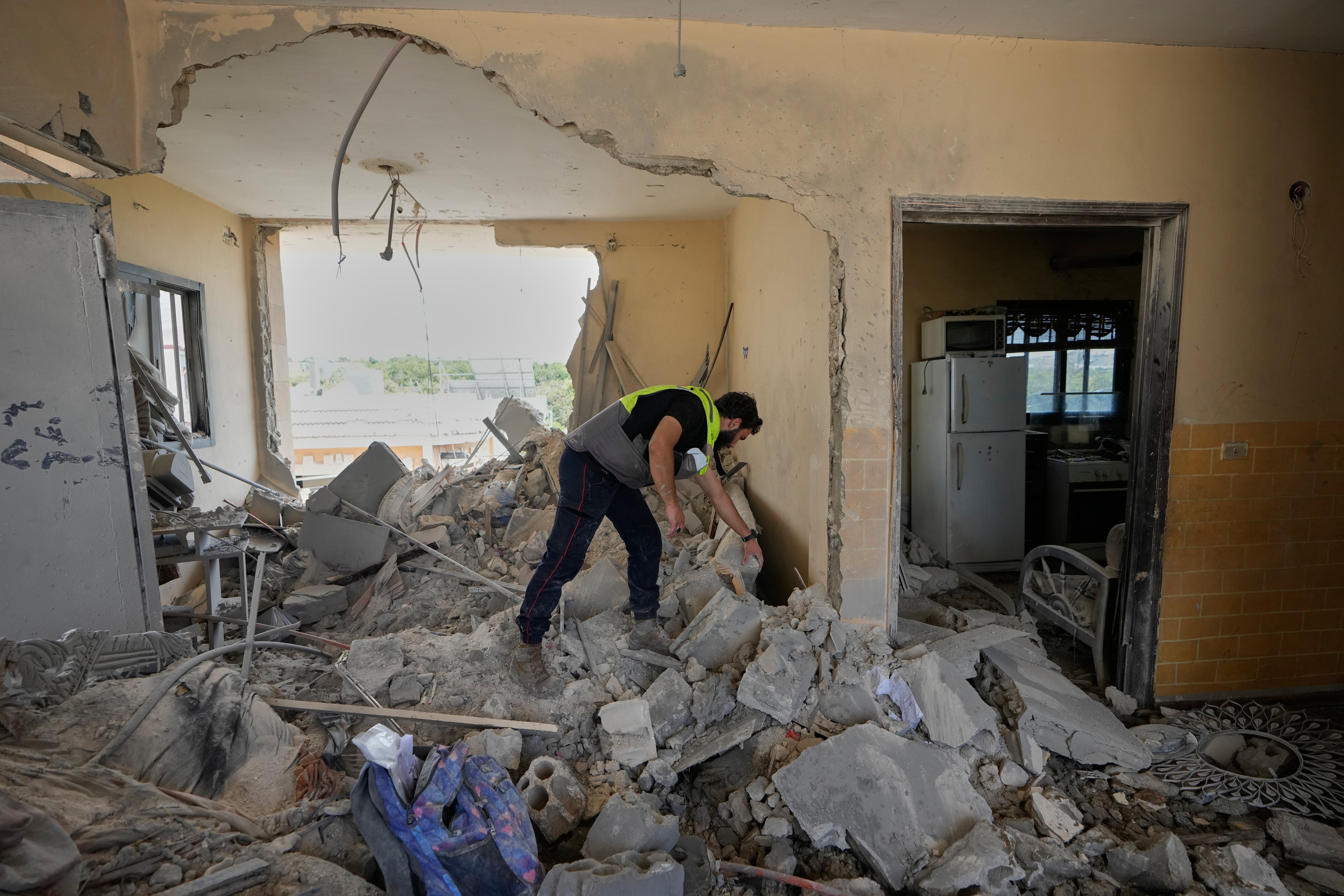 Un rescatista busca entre los escombros de una casa destruida en un ataque aéreo israelí en el sur de Líbano.