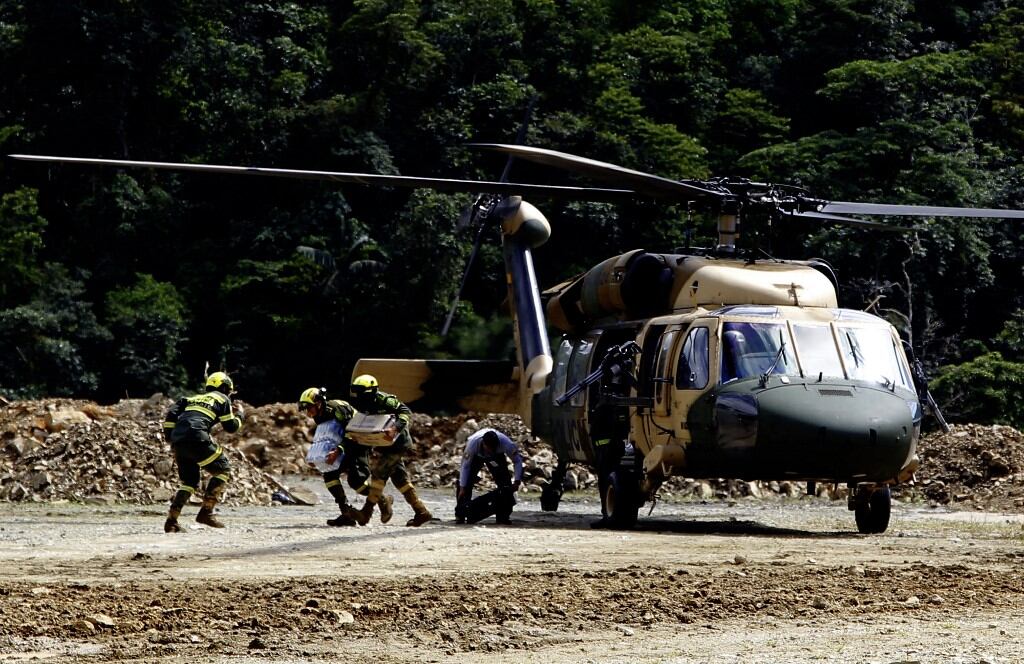 Members of the rescue team arrive at the zone of a landslide in the road between Quibdo and Medellin, Choco department, Colombia on January 13, 2024. At least 23 people were killed and around 20 are injured after a landslide in an indigenous community in northwestern Colombia, an official from the Choco department governor's office told AFP. (Photo by Fredy BUILES / AFP)