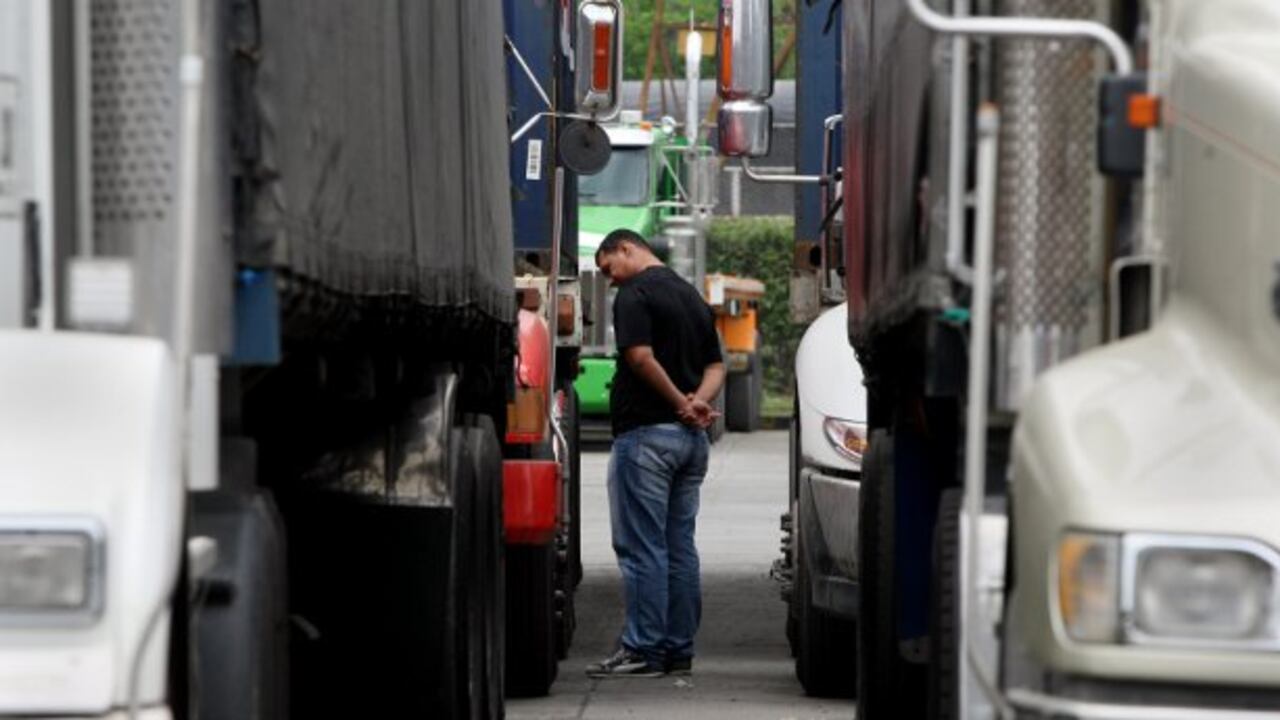 Un hombre camina entre algunos camiones estacionados durante la tercera jornada de protesta, para pedir subsidios tras una nueva subida del carburante la semana pasada en Yumbo.