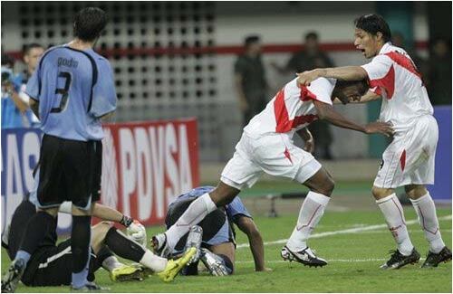 Los peruanos Miguel Villalta y Paolo Guerrero celebran el triunfo ante Uruguay en su partido de apertura de la Copa América en Mérida, Venezuela
