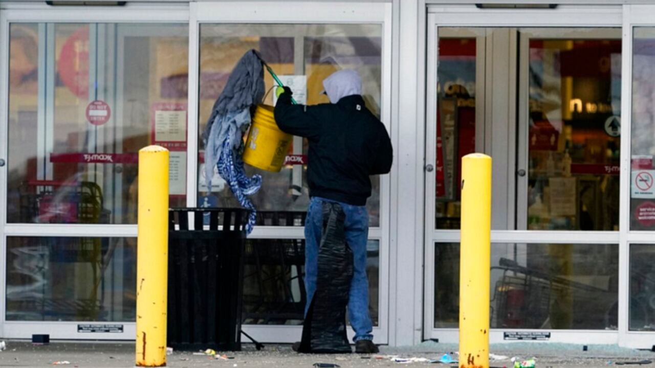 Un trabajador limpia a las afuera de una tienda que fue asaltada durante los disturbios en Brooklyn Center, Minnesota, un suburbio de Minneapolis, que se registraron luego de la muerte de un hombre afroamericano.
