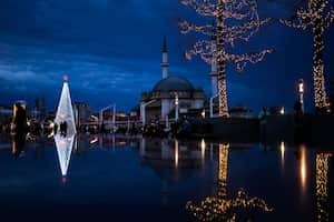 Los peatones pasan junto a un árbol de Navidad junto a la mezquita Taksim en la plaza Taksim en Estambul, Turquía. Foto AP / Francisco Seco