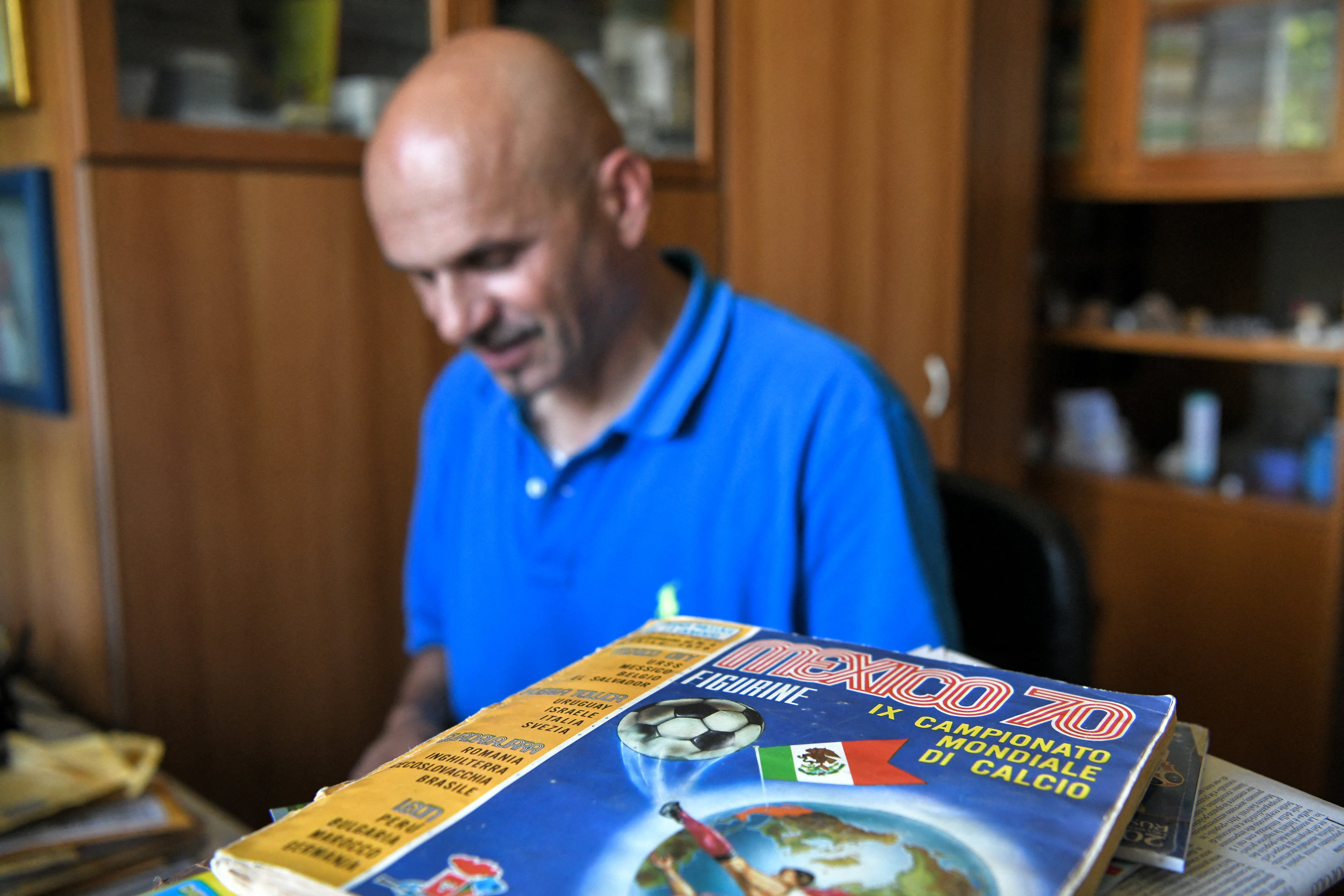 Gianni Bellini, propietario de la colección de pegatinas de fútbol de Panini más grande del mundo, trabaja en su estudio mientras el álbum de Panini del Mundial de México de 1970, una de las piezas más raras de su colección, reposa sobre su escritorio, en San Felice sul Panaro, Módena, el 18 de julio de 2018