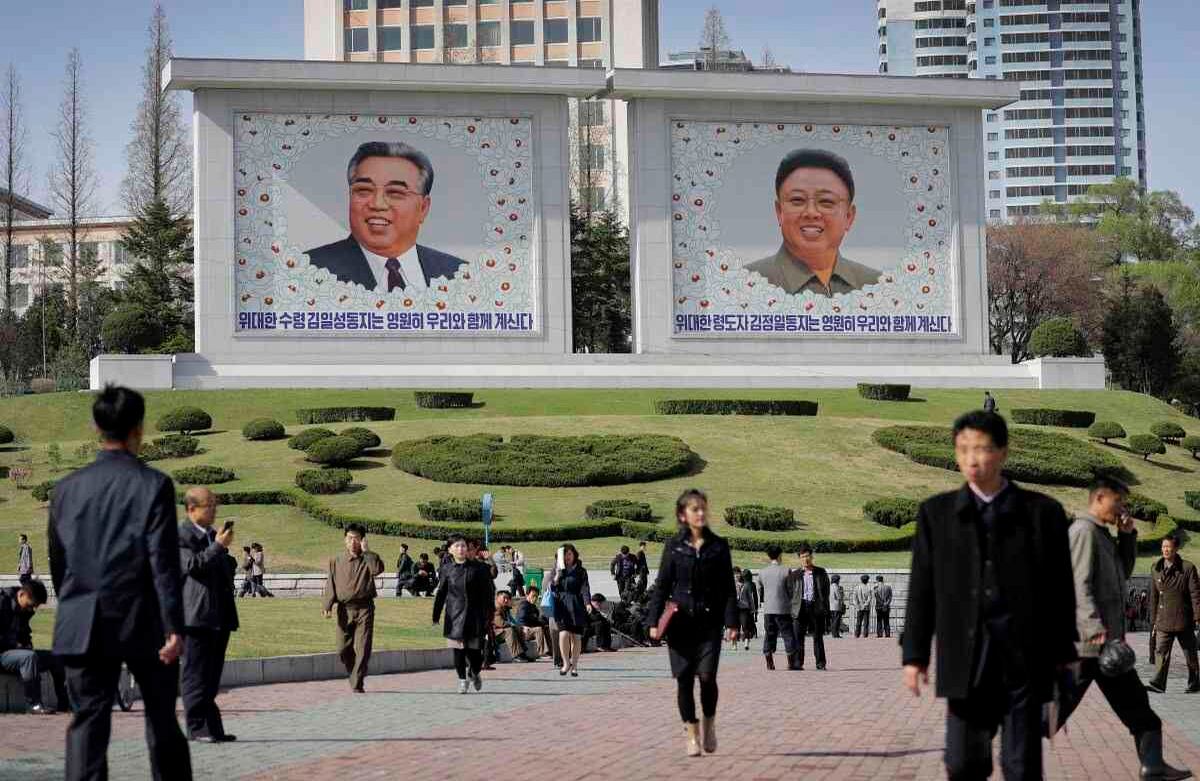 Los norcoreanos caminan por el centro de Pyongyang, donde los retratos de los últimos líderes, Kim Il Sung, a la izquierda, y Kim Jong Un, se ven al fondo el martes, 18 de abril de 2017, en Corea del Norte. Las tensiones han aumentado en las últimas semanas sobre el avance de la tecnología nuclear de Corea del Norte y el arsenal de misiles. (Foto de AP / Wong Maye-E)  