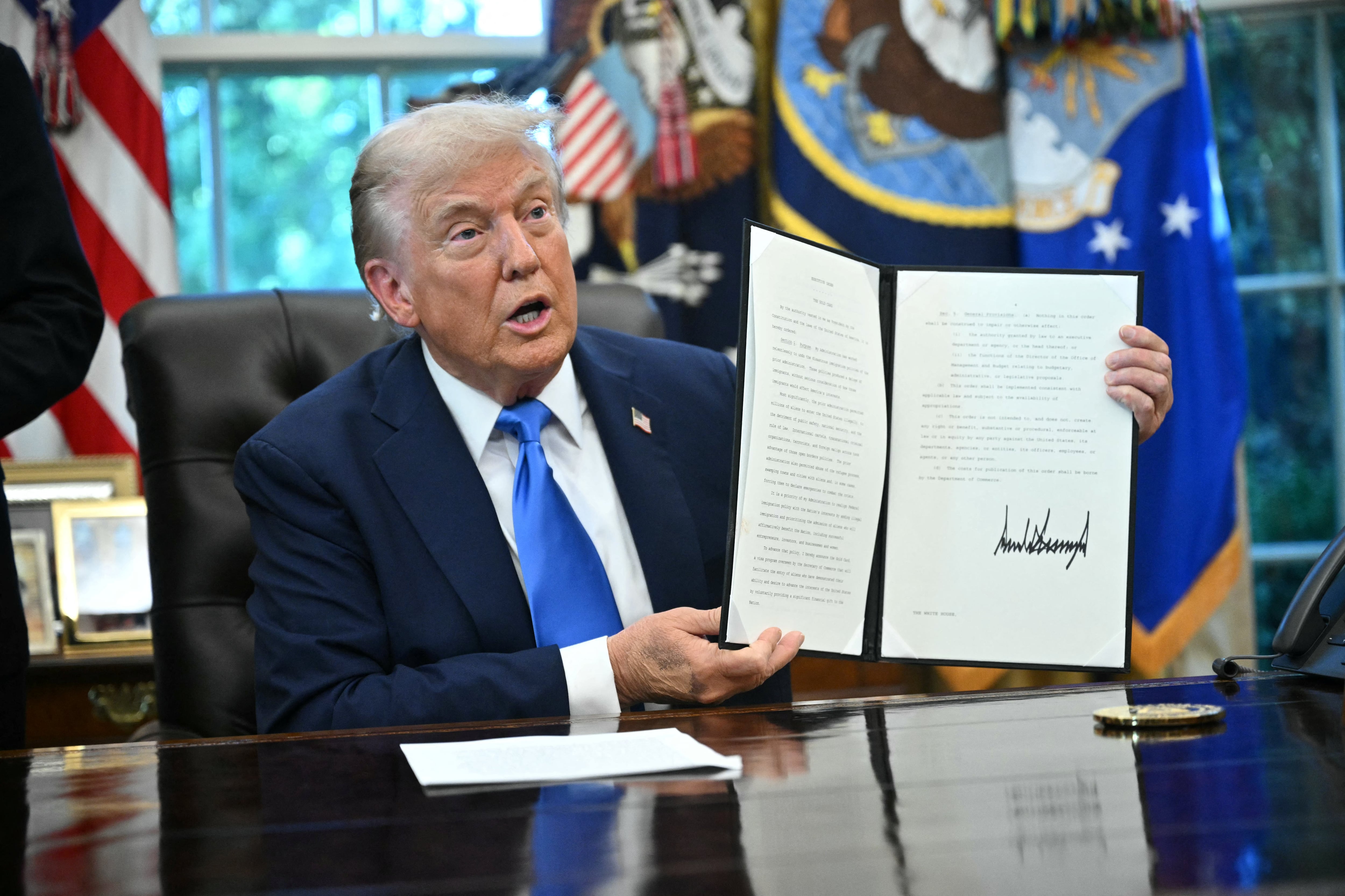El presidente de Estados Unidos, Donald Trump, exhibe una orden ejecutiva que acaba de firmar en el Despacho Oval de la Casa Blanca, en Washington D. C., el 19 de septiembre de 2025.