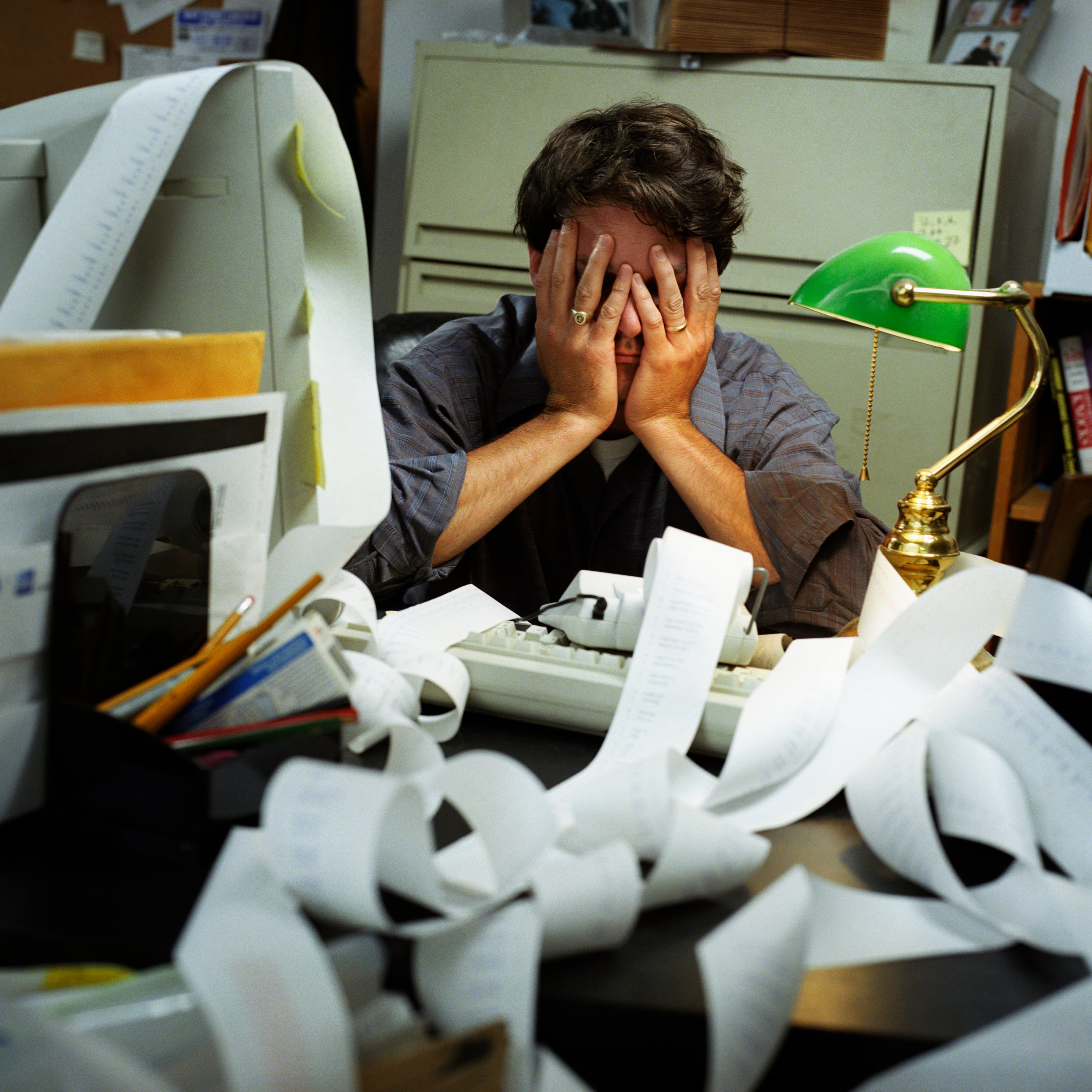 man sleeping at desk with a long stream of adding machine paper strewn across desk,MR_052
