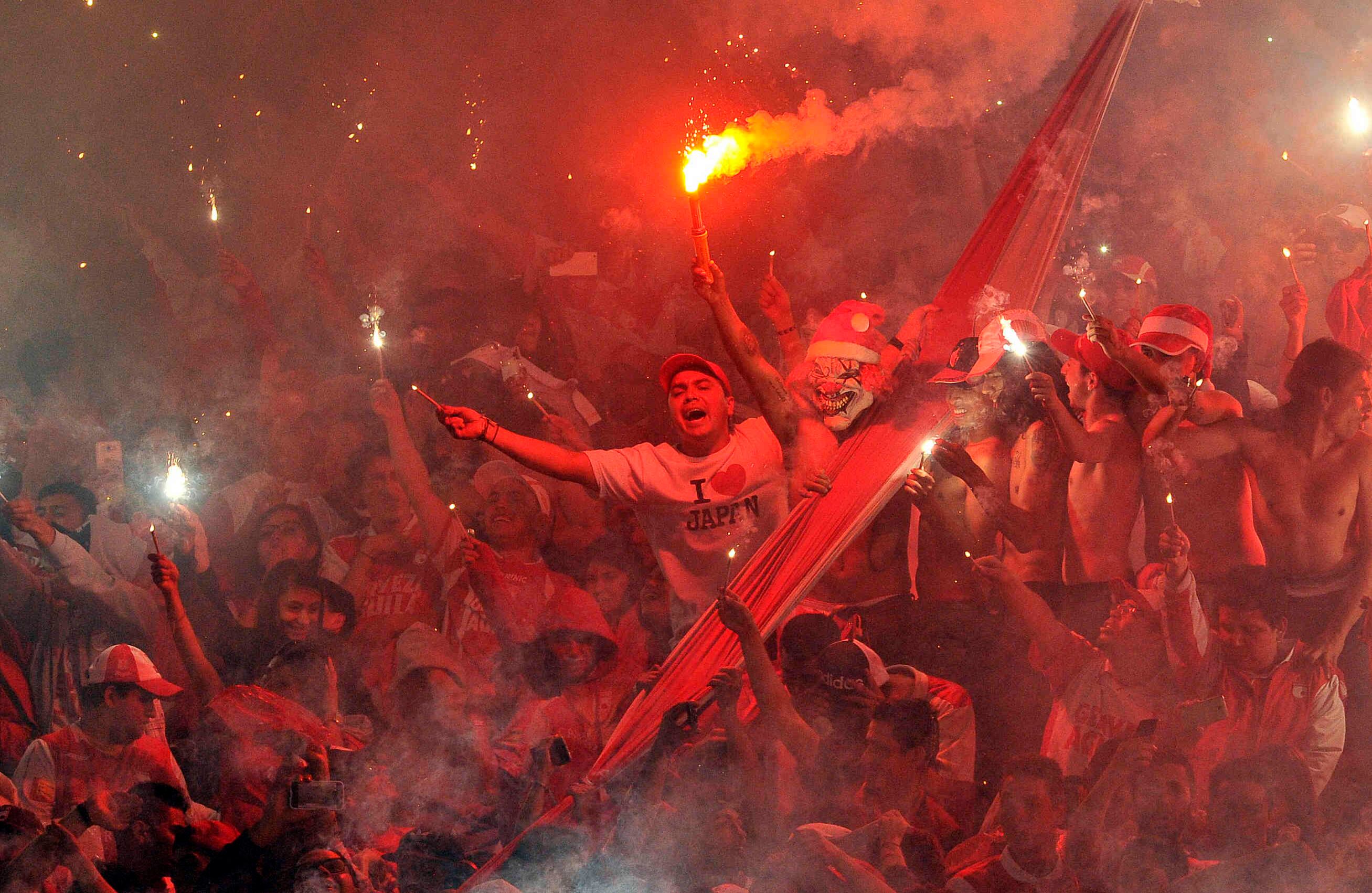 Hinchas del Santa Fe encienden bengalas durante el partido de vuelta frente al Tolima, el domingo 18 de diciembre de 2016, en el Campín, en Bogotá. Al finalizar el partido los cardenales alcanzaron su novena estrella  al derrotar 1-0 a los tolimenses, con un gol de Héctor Urrego, y se proclamó campeón del torneo clausura 2016 del fútbol profesional colombiano.