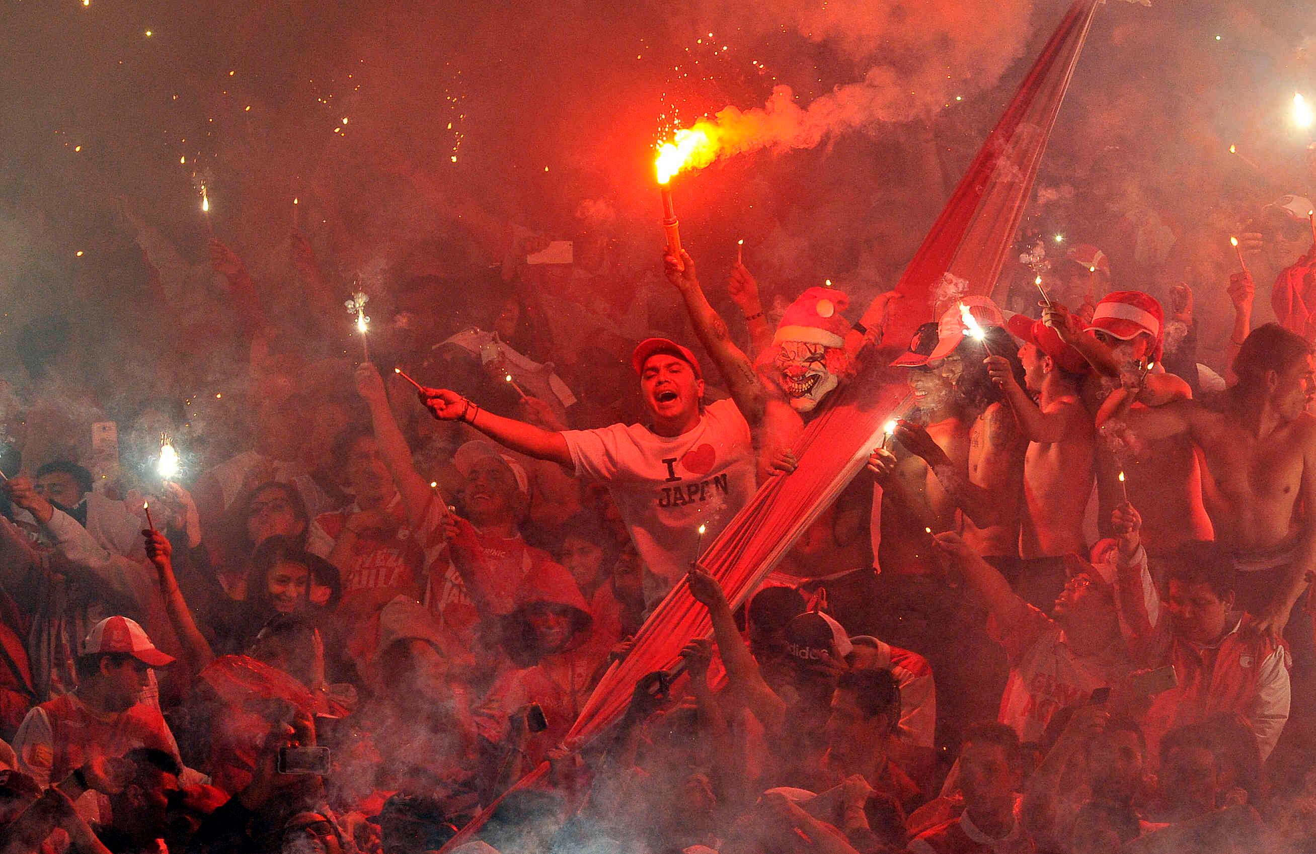 Hinchas del Santa Fe encienden bengalas durante el partido de vuelta frente al Tolima, el domingo 18 de diciembre de 2016, en el Campín, en Bogotá. Al finalizar el partido los cardenales alcanzaron su novena estrella al derrotar 1-0 a los tolimenses, con un gol de Héctor Urrego, y se proclamó campeón del torneo clausura 2016 del fútbol profesional colombiano.