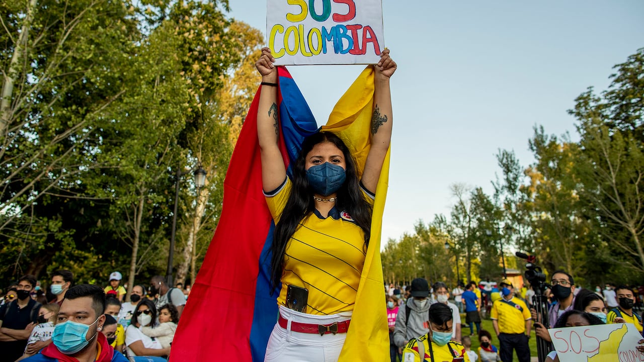 Una mujer sostiene una pancarta que dice: "SOS Colombia" durante una protesta contra la violencia en Colombia contra la reforma fiscal en Madrid, España, el jueves 6 de mayo de 2021. La manifestación es en apoyo de las protestas que comenzaron la semana pasada por una reforma fiscal, propuesta que continúa a pesar del retiro del plan tributario por parte del presidente de Colombia, Iván Duque. Foto: AP / Manu Fernandez.