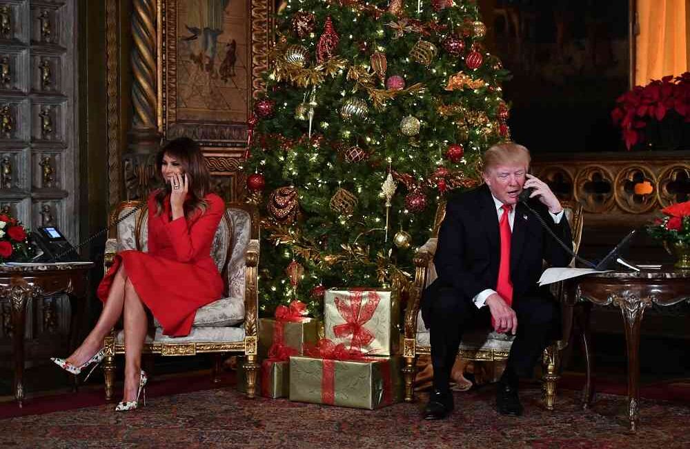 El presidente de EE. UU. Donald J. Trump y la primera dama Melania Trump participan en las llamadas telefónicas de NORAD Santa Tracker en el complejo Mar-a-Lago en Palm Beach, Florida, el 24 de diciembre de 2017. Foto: AFP / Nicholas Kamm