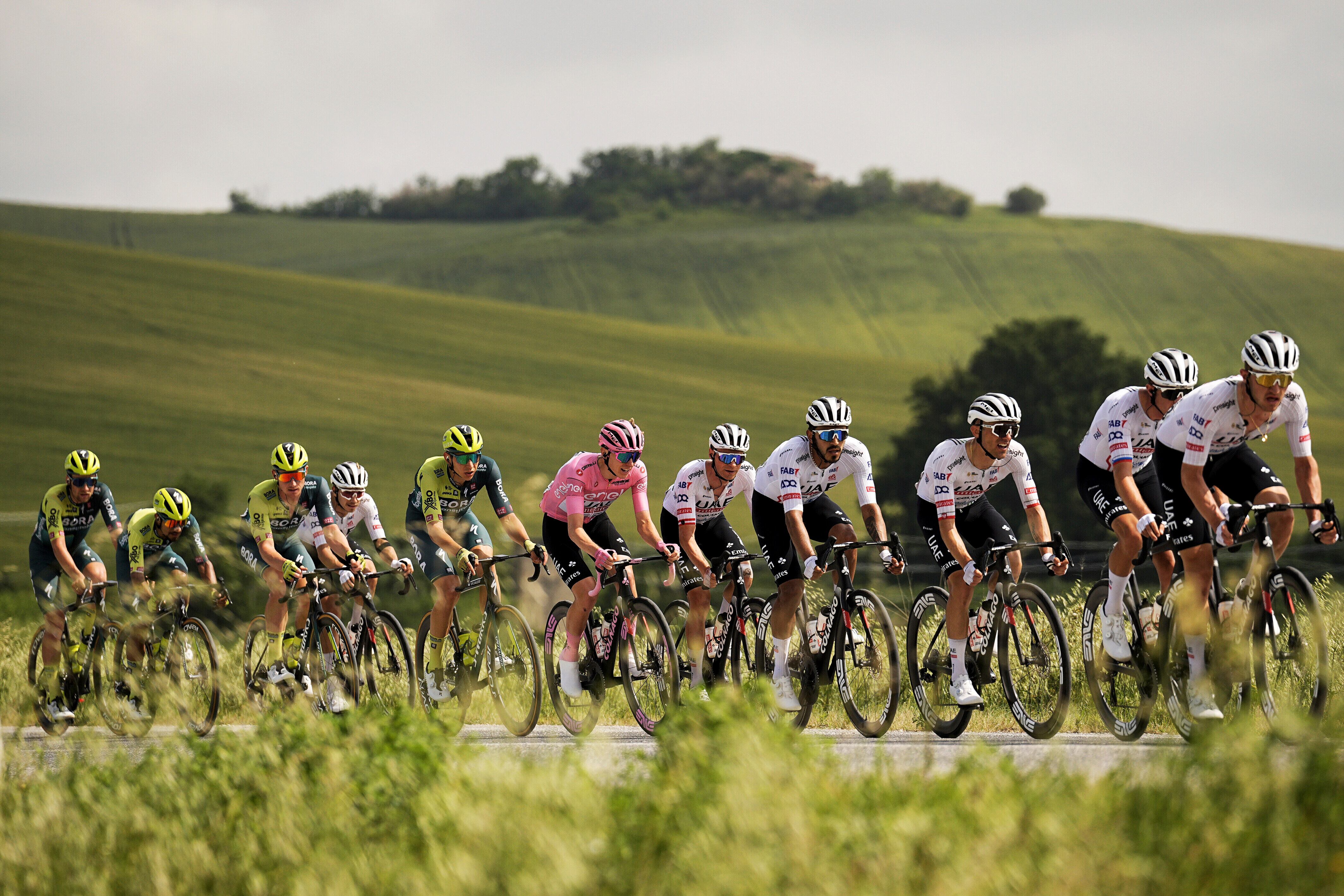 El esloveno Tadej Pogacar, sexto desde la derecha, vistiendo la camiseta rosa del líder general de la carrera, pedalea en el pelotón durante la duodécima etapa de la carrera ciclista Giro de Italia de Martinsicuro a Fano, Italia, el jueves 16 de mayo de 2024. (Marco Alpozzi/LaPresse vía AP)