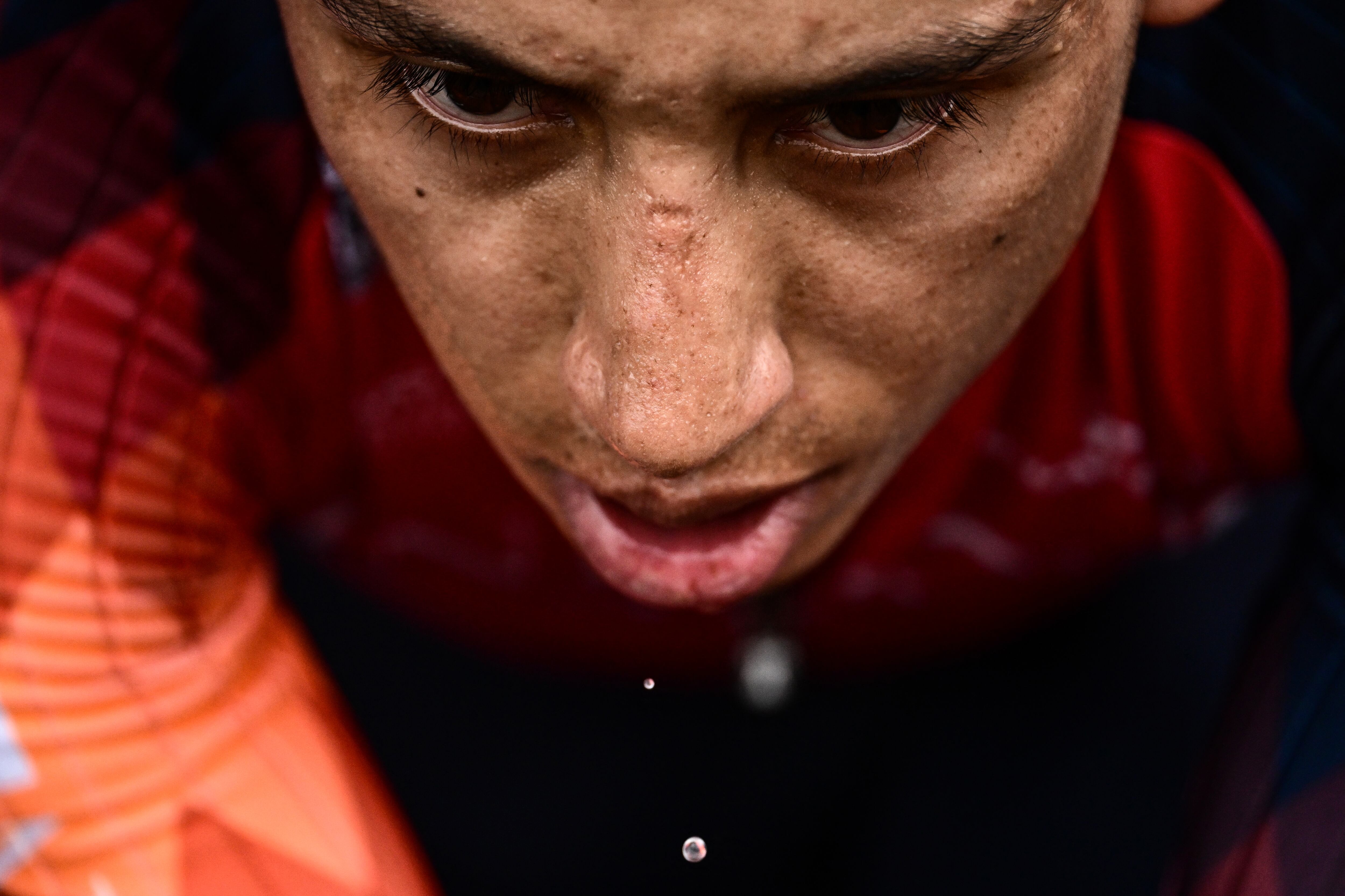 Beads of sweat drip from the face of INEOS - Grenadiers' Colombian rider Egan Bernal as he cycles on a home-trainer bicycle outside his team's bus, in Bilbao, northern Spain, on June 30, 2023, on the eve of the start of the 110th edition of the Tour de France cycling race. (Photo by Marco BERTORELLO / AFP)