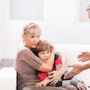 Mature father is scolding his son while mother is defending him.