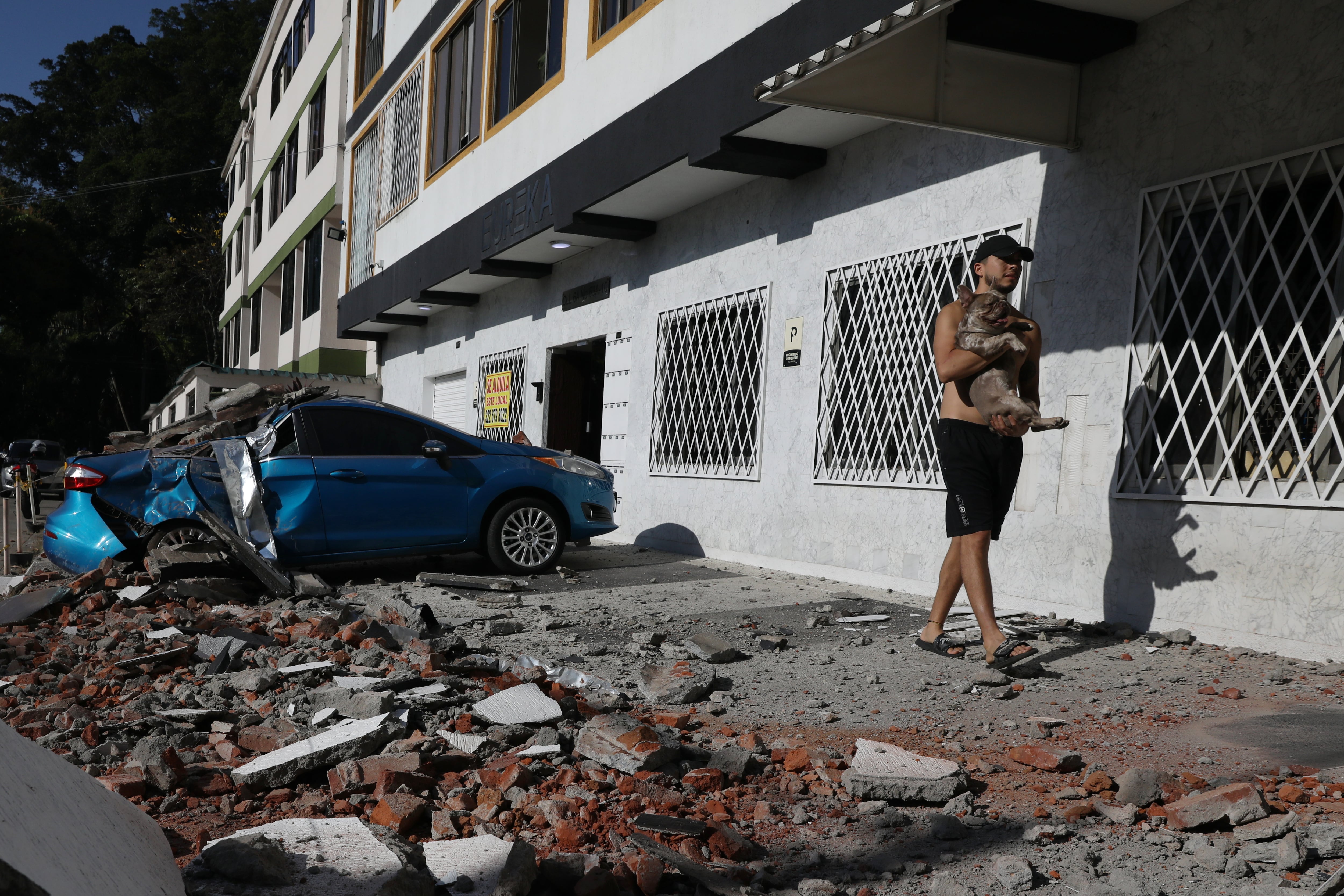 Un hombre carga a su perro después de que un terremoto azotara Cali, Colombia, el lunes 10 de agosto de 2026.