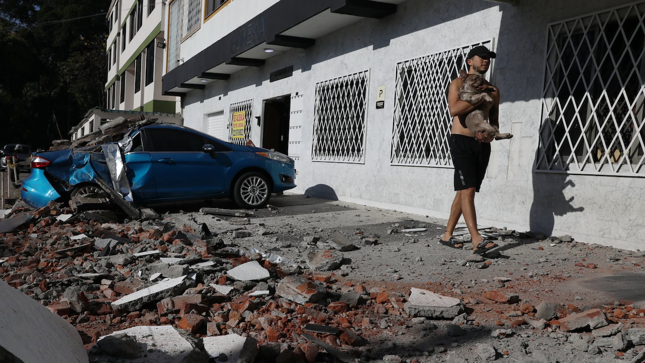 Un hombre carga a su perro después de que un terremoto azotara Cali, Colombia, el lunes 10 de agosto de 2026.