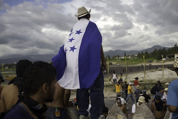Los hondureños partidarios del derrocado presidente Manuel Zelaya iniciaron su protesta con la firme intención de mantenerse unidos y pacíficos arropados con la bandera.