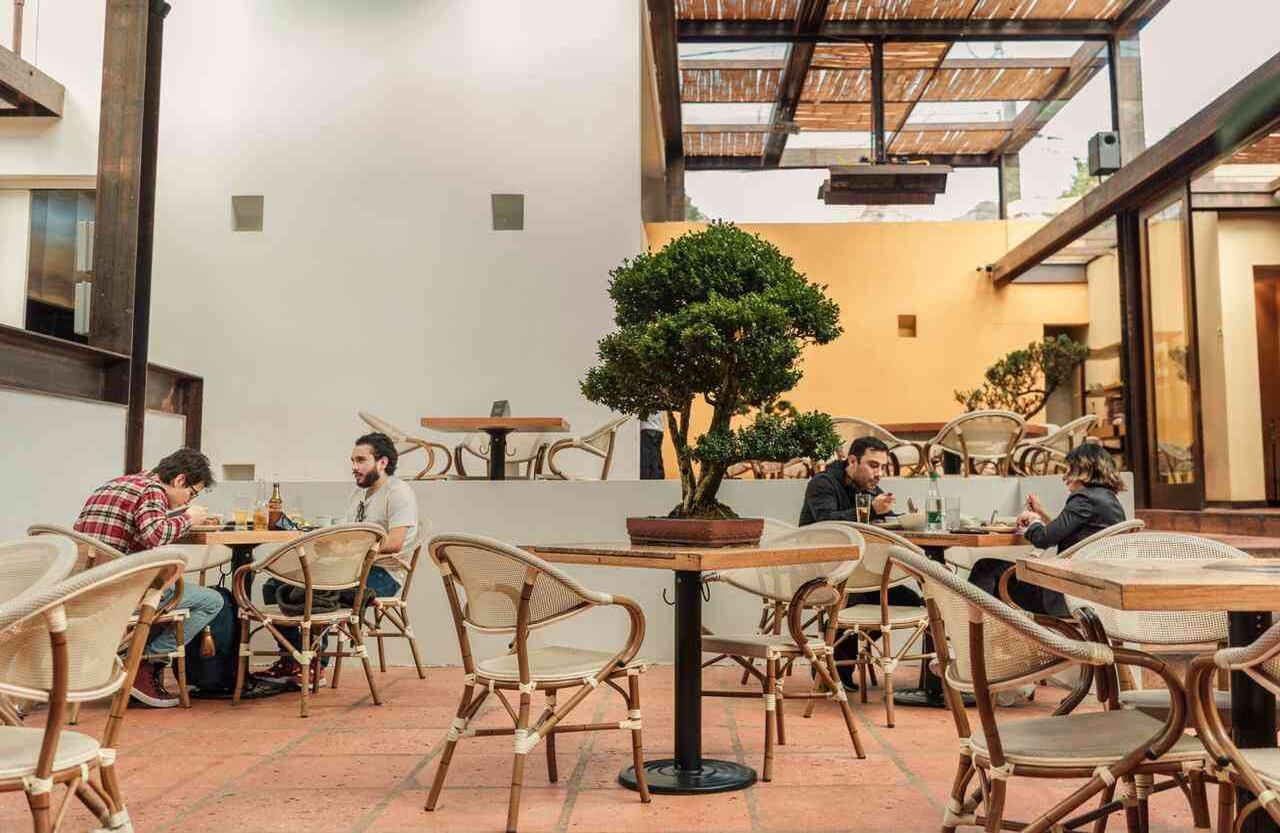 Bajo las normas de la alcaldía, al interior de los restaurantes solo puede ingresar el 25% del aforo. Mientras algunos guardaron las mesas que no pueden usar, otros, como 7-56 del Grupo Zona K, las decoran para crear un ambiente acogedor. 