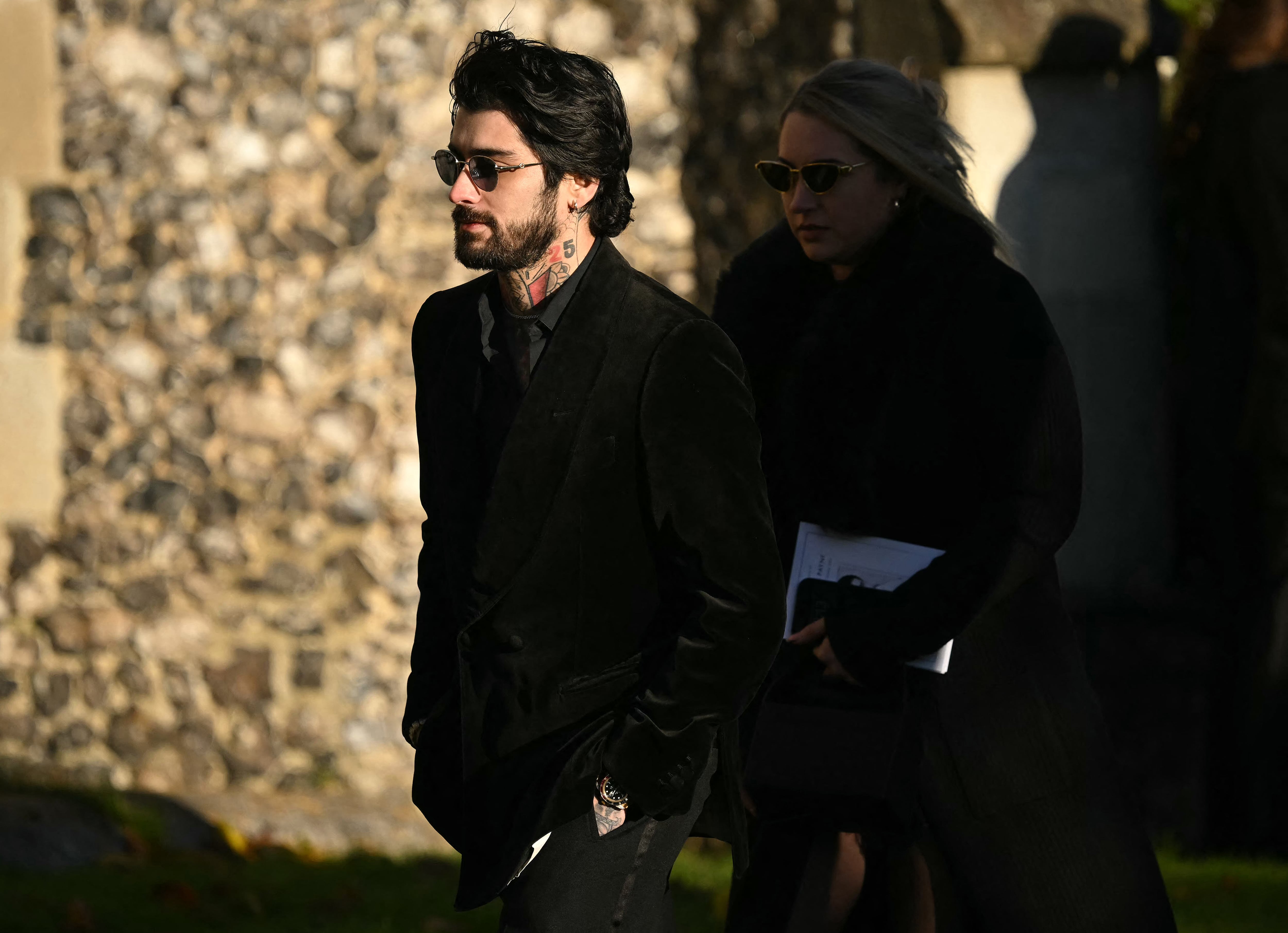 El ex miembro de la banda One Direction, Zayn Malik (izq.), se va después de asistir al funeral del fallecido cantante de One Direction, Liam Payne, en una iglesia de St Mary en Amersham, al oeste de Londres, el 20 de noviembre de 2024. El funeral del ex cantante de One Direction, Liam Payne, quien murió el mes pasado tras caerse de su habitación de hotel en Buenos Aires, se celebró el miércoles. (Foto de JUSTIN TALLIS / AFP)