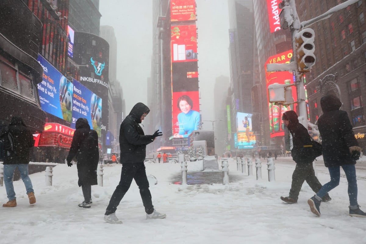 La gente camina por Times Square en medio de una tormenta de nieve el 23 de febrero de 2026 en la ciudad de Nueva York