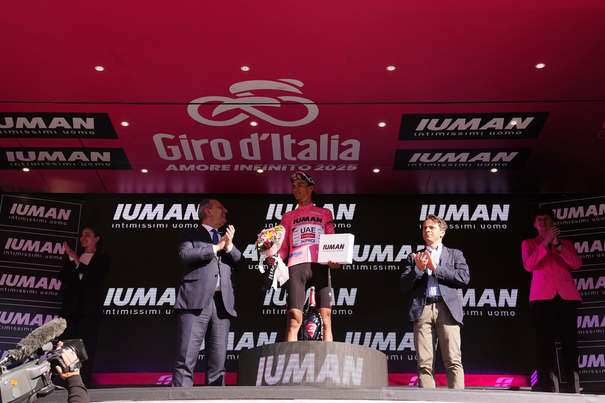 Isaac del Toro, new pink jersey, celebrates on the podium after stage 9 of the Giro d'Italia from Gubbio to Siena, Italy - Sunday, May 18, 2025. (Fabio Ferrari/Lapresse/LaPresse via AP)