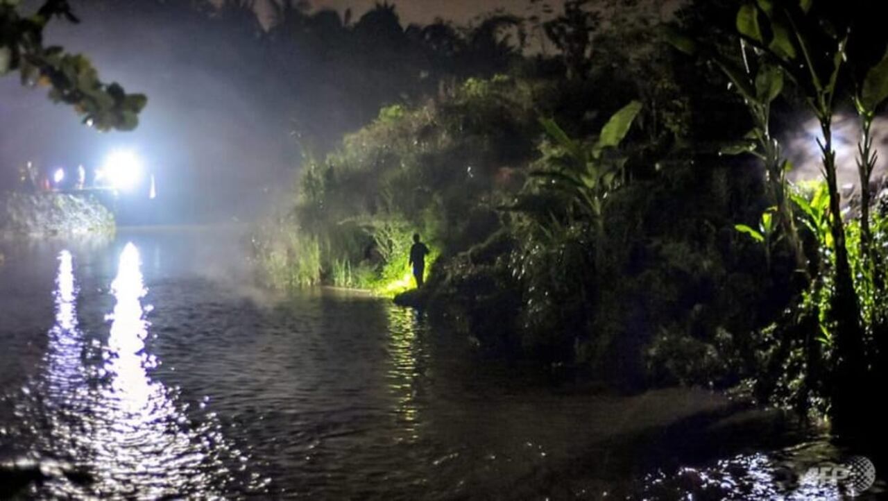 Esta imagen tomada el 21 de febrero de 2020 muestra al personal de rescate usando reflectores a lo largo de un río mientras busca a los estudiantes desaparecidos de un grupo de exploradores, que fueron arrastrados por las inundaciones repentinas, en Yogyakarta AFP