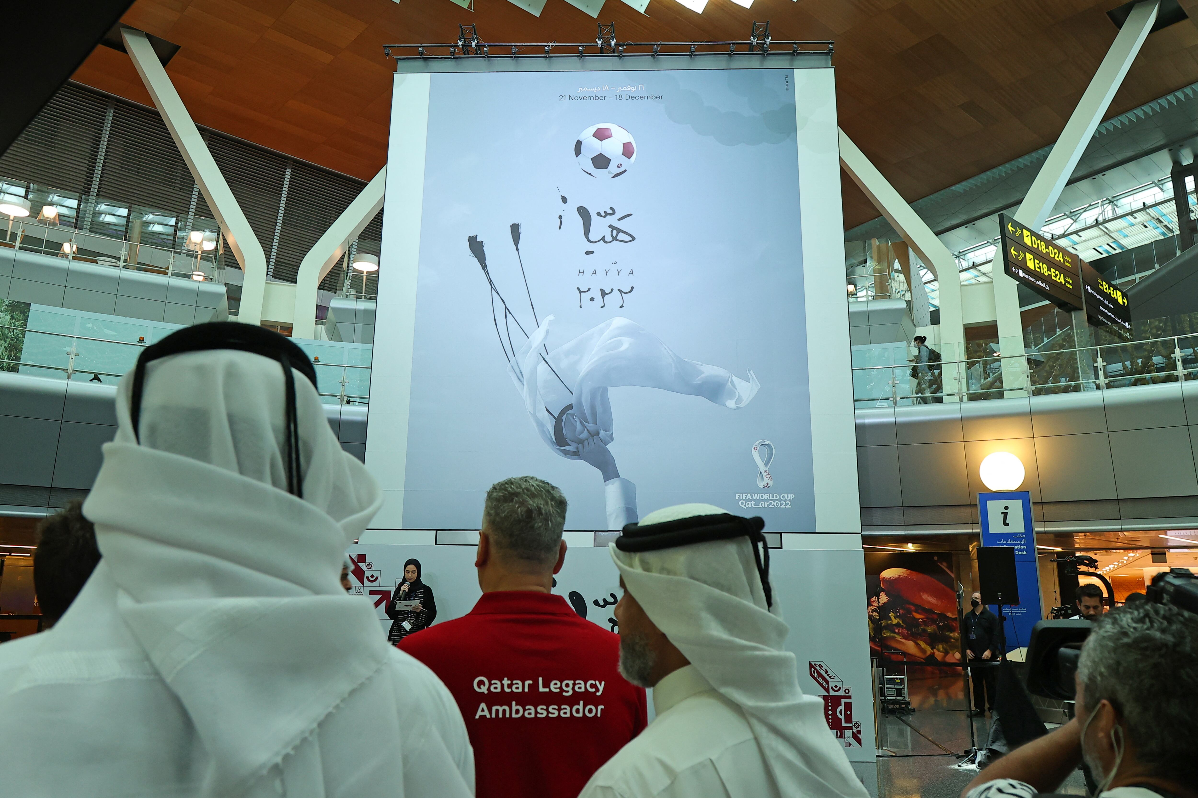 The official poster of Qatar's FIFA World Cup is unveiled at Hamad International Airport in Doha on June 15, 2022. (Photo by KARIM JAAFAR / AFP)