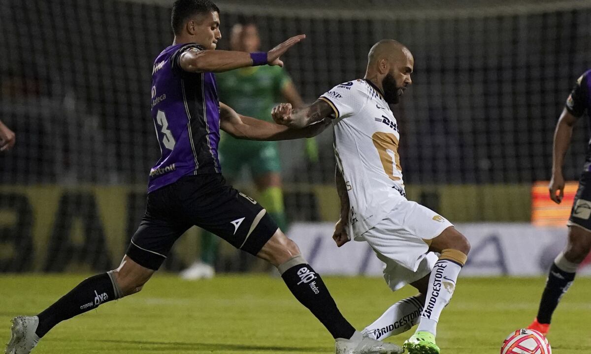 El brasileño Dani Alves, de Pumas, disputa un balón con Alan López, de Mazatlán, durante un partido de la Liga MX, el miércoles 27 de julio de 2022 (AP/Eduardo Verdugo)