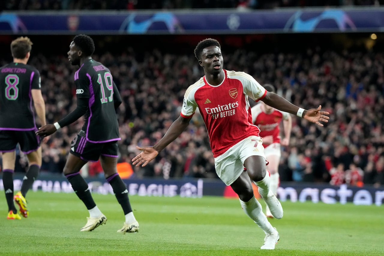 Arsenal's Martin Odegaard, center, celebrates after Bukayo Saka scored the opening goal during the Champions League quarter final first leg soccer match between Arsenal and Bayern Munich at the Emirates Stadium, London, Tuesday, April 9, 2024. (AP Photo/Frank Augstein)