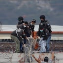 Grupo de rescate intentan bajar el cuerpo de uno de los muertos en la masacre en la cárcel de Ecuador