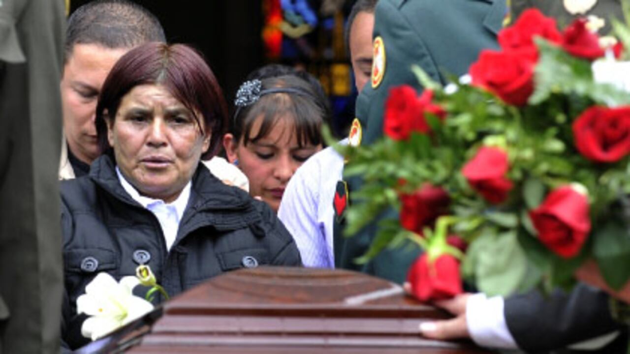 Cecilia Ramírez , con el ataúd de su hijo, José Ricardo Rodríguez, conductor del exministro Fernando Londoño, asesinado en el atentado contra él.