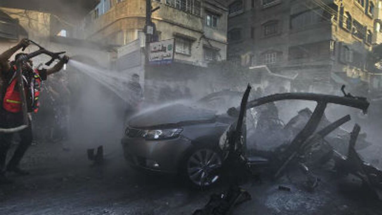 Bomberos tratan de extinguir el carro destrozado de Ahmed Yabari, jefe del brazo armado de Hamas, abatido en un ataque aéreo israelí en la Franja de Gaza.