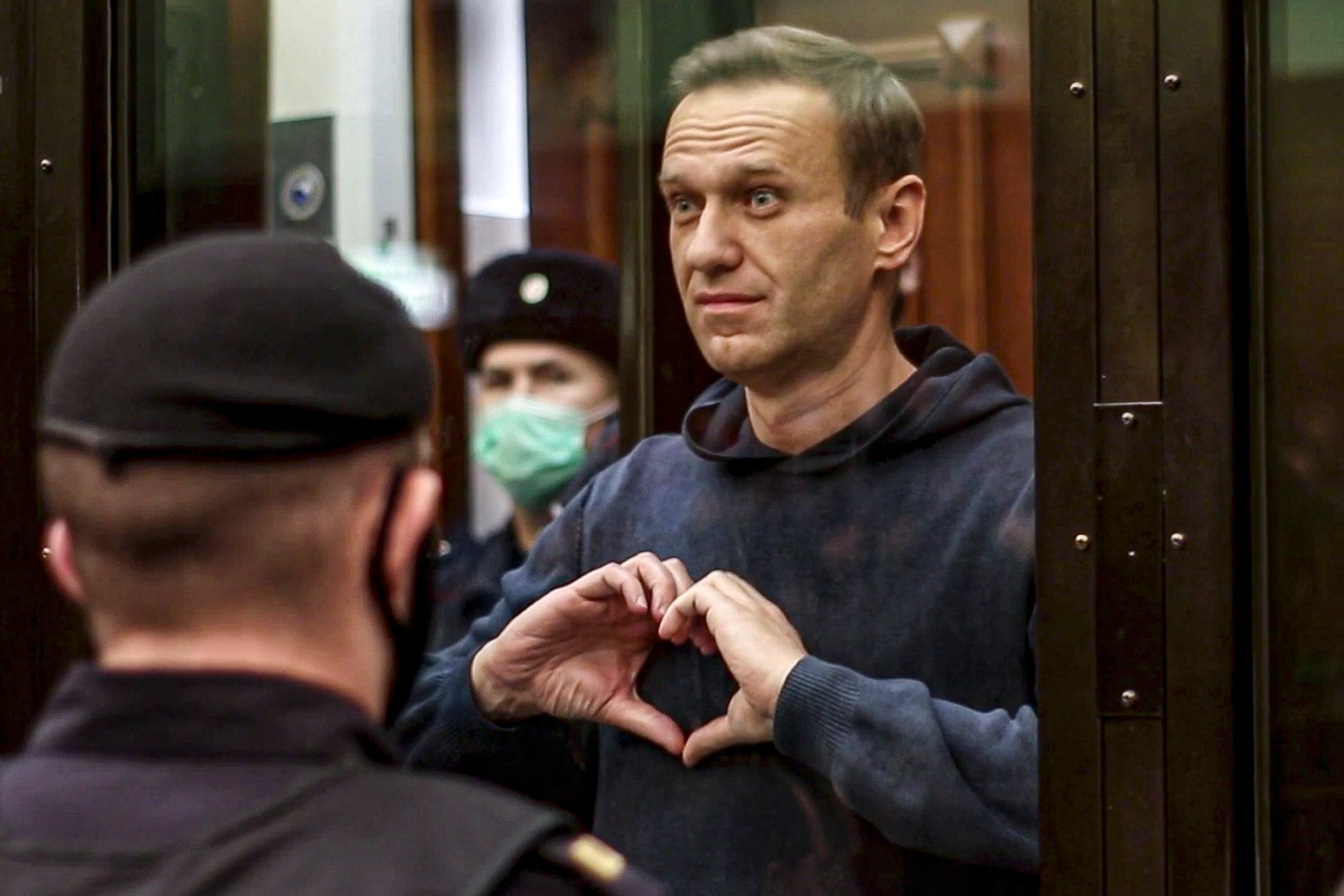 El líder de la oposición rusa Alexei Navalny hace un gesto con el corazón en una jaula durante una audiencia a una moción del servicio penitenciario ruso para convertir la sentencia suspendida de Navalny de la condena penal de 2014 en una pena de prisión real en el Tribunal de la ciudad de Moscú en Moscú, Rusia.