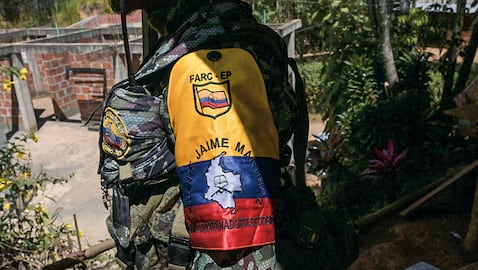 Un guerrillero de la disidencia de las FARC «Jaime Martínez» hace guardia mientras el comandante Andrey concede una entrevista cerca del municipio de Suárez, en el departamento del Cauca, el 30 de agosto de 2023. El grupo disidente EMC, que rechazó el acuerdo de paz de 2016 que condujo al desarme de las FARC, iniciará conversaciones de paz directas con el Gobierno colombiano el 31 de agosto. (Photo by JOAQUIN SARMIENTO / AFP)
