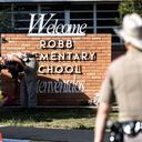 UVALDE, TX - MAY 25: A Texas State Trooper receives flowers for the victims of a mass shooting yesterday at Robb Elementary School where 21 people were killed, including 19 children, on May 25, 2022 in Uvalde, Texas. The shooter, identified as 18-year-old Salvador Ramos, was reportedly killed by law enforcement. (Photo by Jordan Vonderhaar/Getty Images)