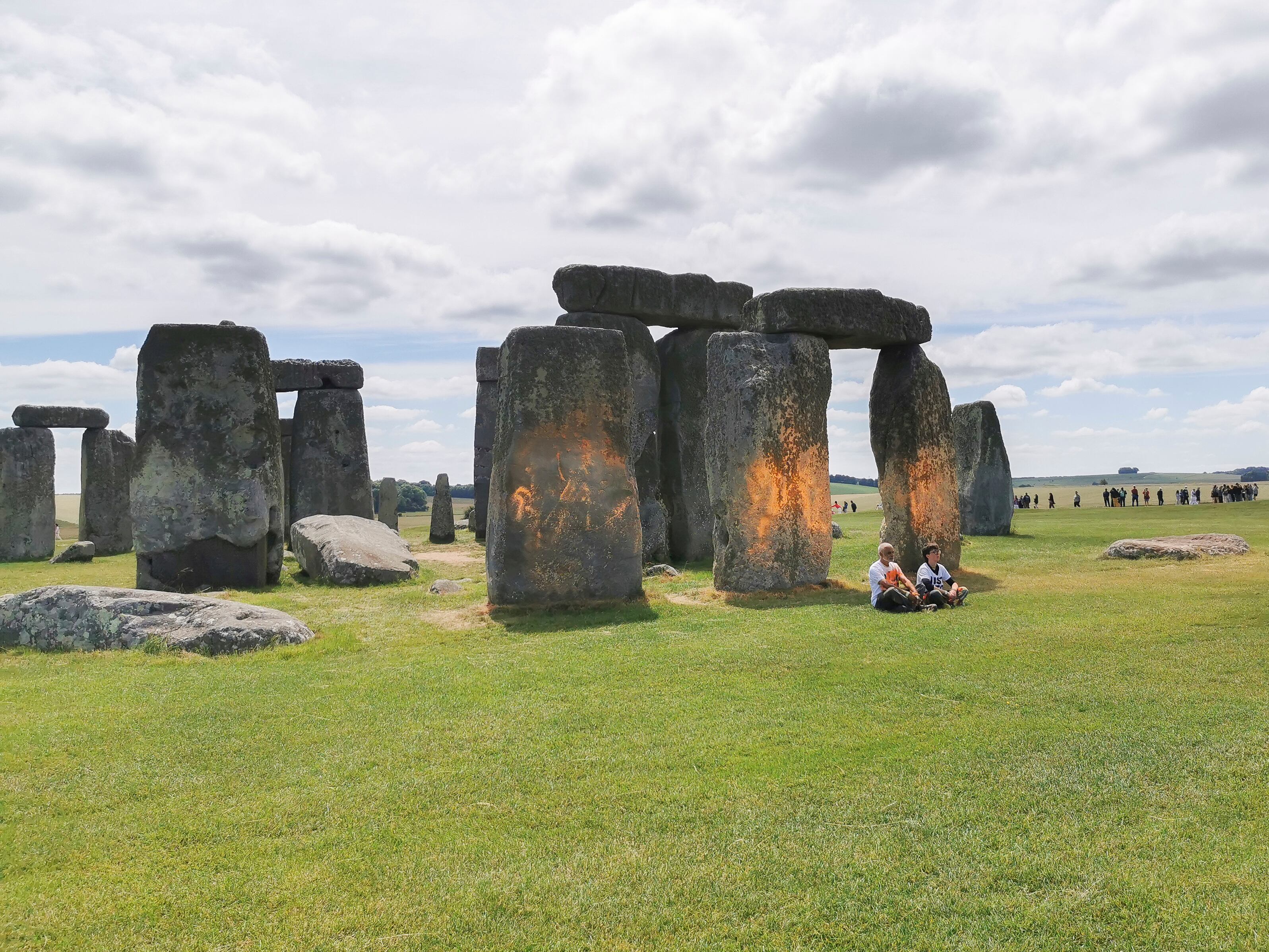 En esta foto distribuida, los manifestantes de Just Stop Oil se sientan después de rociar una sustancia naranja en Stonehenge, en Salisbury, Inglaterra, el miércoles 19 de junio de 2024.