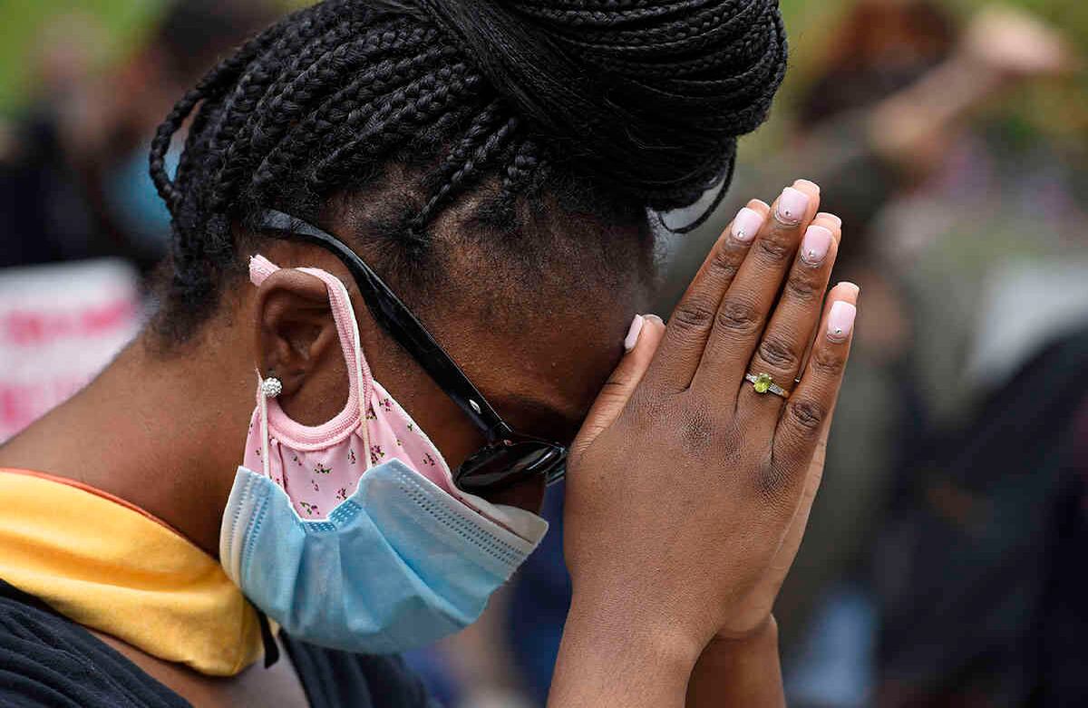 Una manifestante baja la cabeza para rezar durante un momento de silencio después de marchar hacía el Departamento de Policía de Hayward en California, el domingo 31 de mayo de 2020. Foto: Jose Carlos Fajardo / Grupo de Noticias del Área de la Bahía vía AP.