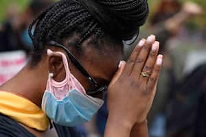 Una manifestante baja la cabeza para rezar durante un momento de silencio después de marchar hacía el Departamento de Policía de Hayward en California, el domingo 31 de mayo de 2020. Foto: Jose Carlos Fajardo / Grupo de Noticias del Área de la Bahía vía AP.
